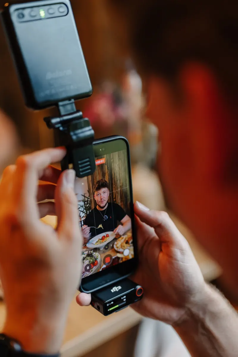 Smartphone mit Mikrofon und Licht während einer Reel-Aufnahme